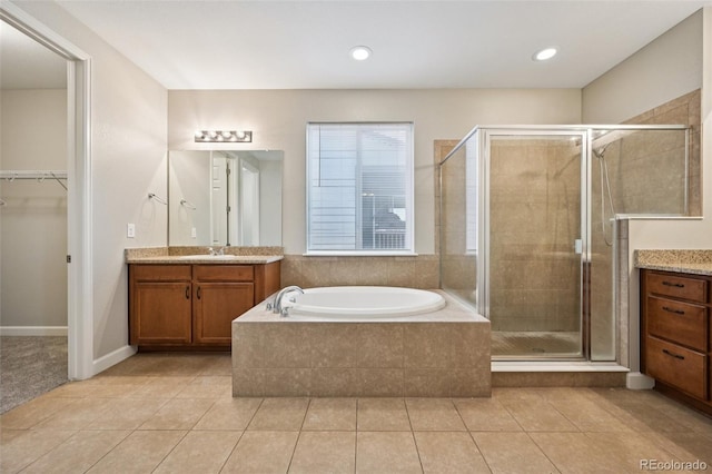 17710 E Emilia Dr, Parker, CO 80134 - full bathroom featuring vanity, a shower stall, a garden tub, and tile patterned floors