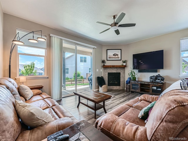 7702 E 157th Ave, Thornton, CO 80602 - living area with a ceiling fan, plenty of natural light, wood finished floors, and a glass covered fireplace