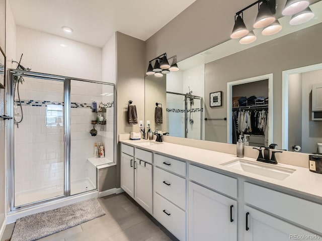 7702 E 157th Ave, Thornton, CO 80602 - full bathroom with a shower stall, double vanity, a walk in closet, and tile patterned floors