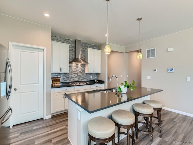 7702 E 157th Ave, Thornton, CO 80602 - kitchen with wall chimney range hood, stainless steel appliances, dark countertops, backsplash, and a kitchen breakfast bar