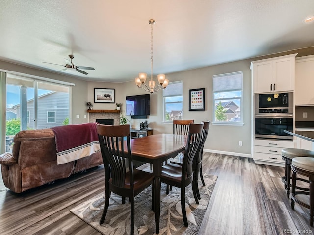 7702 E 157th Ave, Thornton, CO 80602 - dining room with dark wood-style flooring, a ceiling fan, a chandelier, and a fireplace