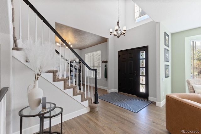 7106 Cerney Cir, Castle Pines, CO 80108 - foyer featuring an inviting chandelier, baseboards, stairs, and wood finished floors