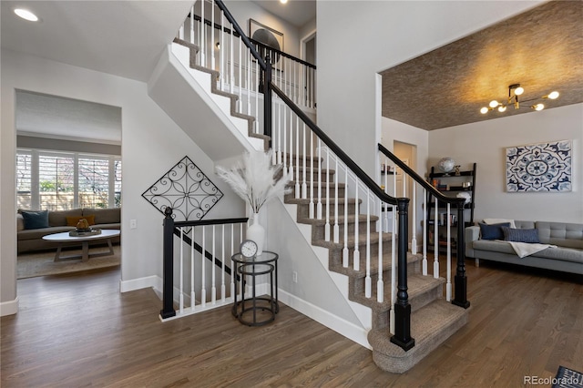 7106 Cerney Cir, Castle Pines, CO 80108 - staircase featuring baseboards, wood finished floors, and a chandelier