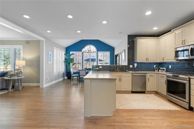 7106 Cerney Cir, Castle Pines, CO 80108 - kitchen featuring a peninsula, a chandelier, a sink, light wood-style flooring, and stainless steel appliances