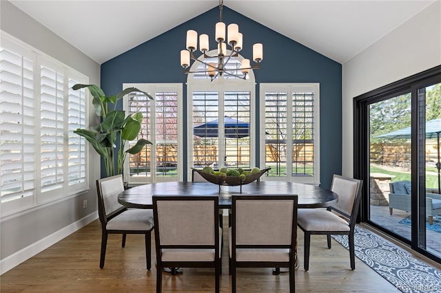 7106 Cerney Cir, Castle Pines, CO 80108 - dining room featuring plenty of natural light, vaulted ceiling, wood finished floors, and a notable chandelier
