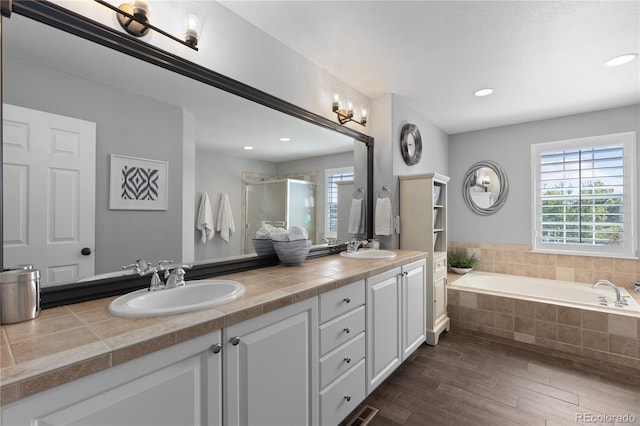 7106 Cerney Cir, Castle Pines, CO 80108 - bathroom featuring a sink, wood finished floors, and a wealth of natural light