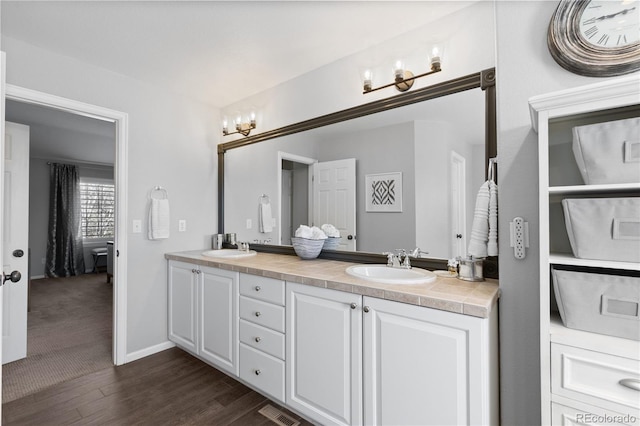 7106 Cerney Cir, Castle Pines, CO 80108 - full bath with double vanity, visible vents, a sink, and wood finished floors