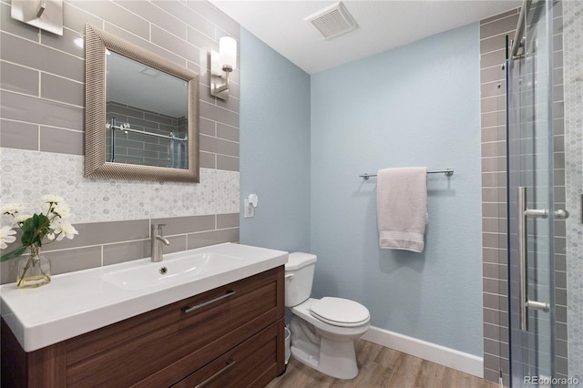 7106 Cerney Cir, Castle Pines, CO 80108 - full bathroom featuring visible vents, a tile shower, wood finished floors, vanity, and toilet
