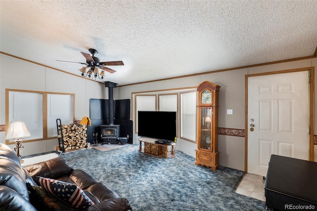 carpeted living room featuring ceiling fan, ornamental molding, a textured ceiling, and a wood stove