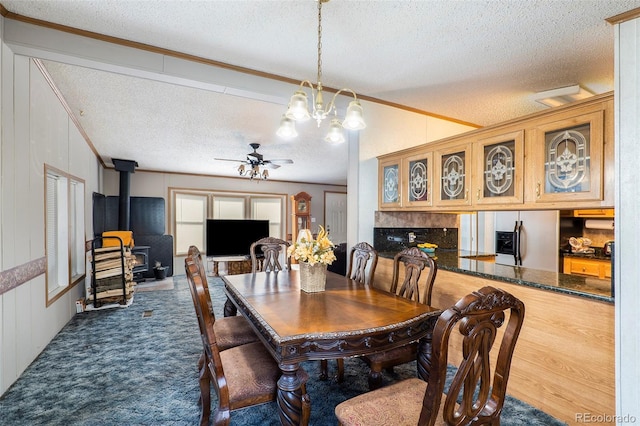 carpeted dining space featuring crown molding, ceiling fan with notable chandelier, a textured ceiling, and a wood stove