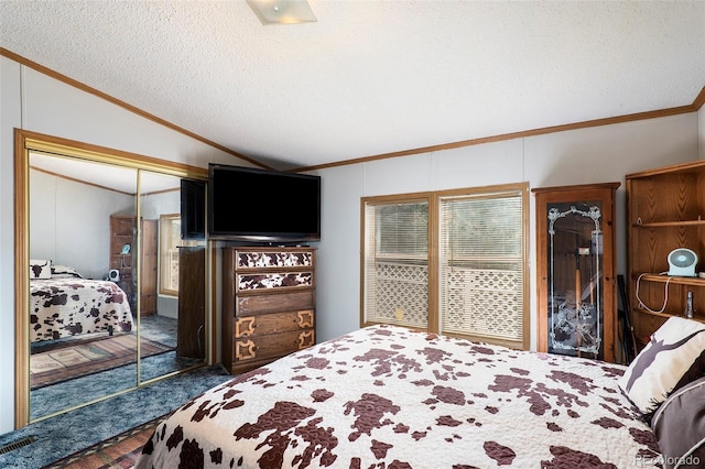 bedroom with crown molding, vaulted ceiling, a closet, and a textured ceiling