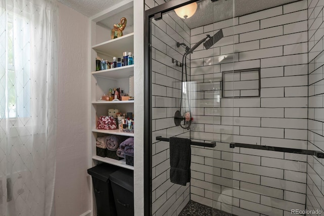 bathroom with a tile shower and a textured ceiling