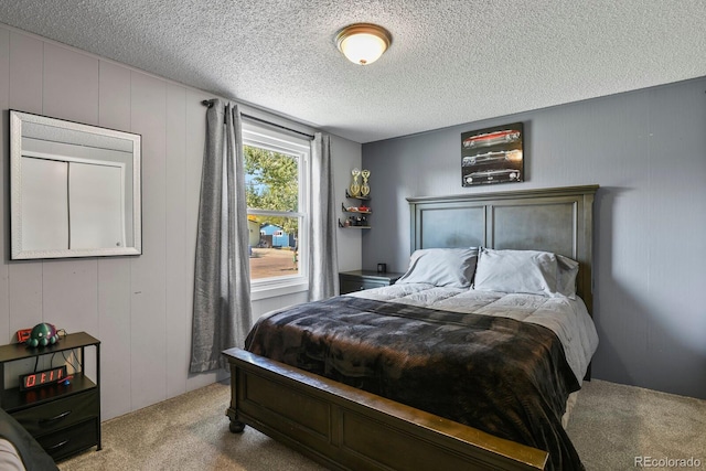 bedroom with light carpet and a textured ceiling