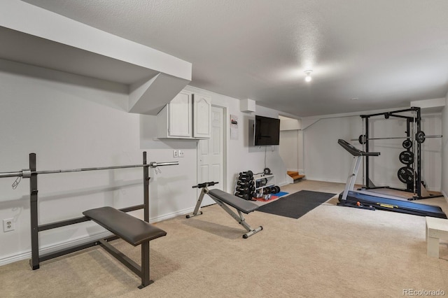 exercise room with light carpet and a textured ceiling