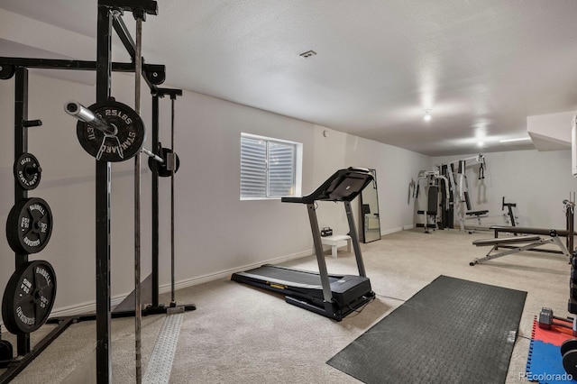 exercise area featuring a textured ceiling and light colored carpet