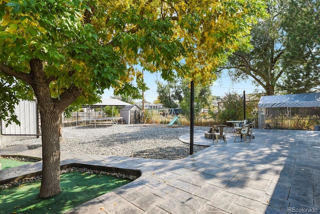 view of patio / terrace with a playground and a storage shed