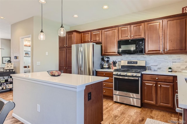 kitchen with light hardwood / wood-style floors, stainless steel appliances, hanging light fixtures, and a center island