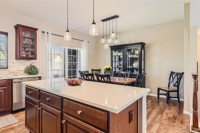 kitchen featuring light wood-type flooring, a center island, pendant lighting, and dishwasher