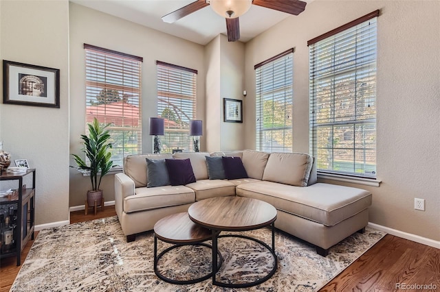 living room with ceiling fan, plenty of natural light, and wood-type flooring