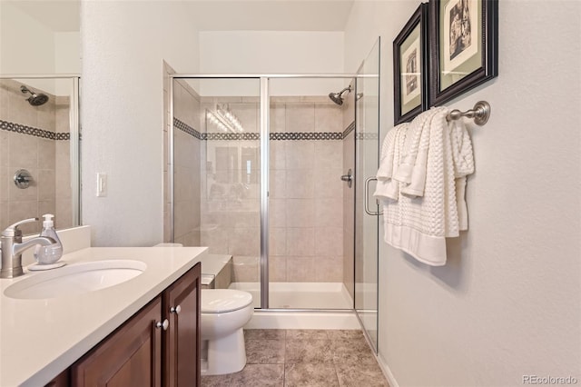 bathroom featuring tile patterned floors, toilet, vanity, and a shower with door