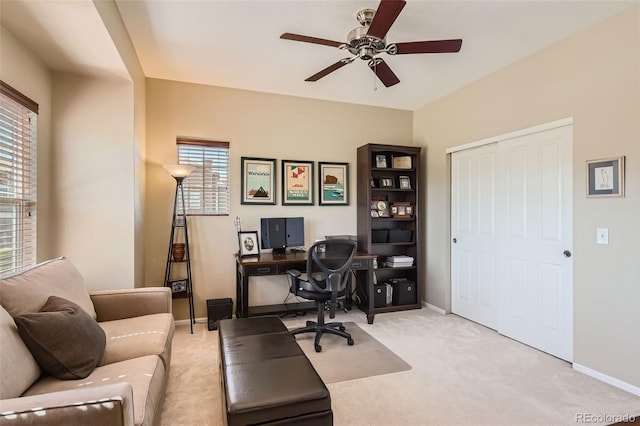 home office with ceiling fan and light carpet