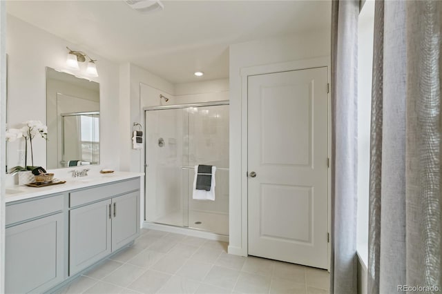 bathroom featuring a shower with door, vanity, and tile patterned floors