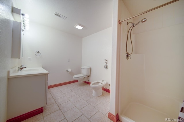 bathroom with walk in shower, toilet, a bidet, vanity, and tile patterned flooring