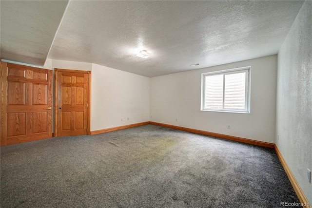 unfurnished room featuring a textured ceiling and carpet