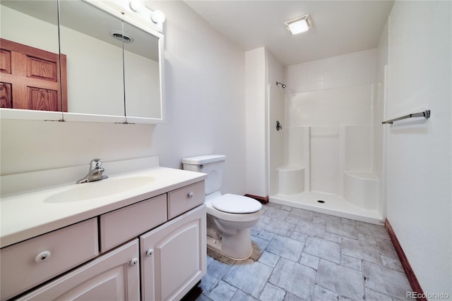 bathroom featuring vanity, a shower, and toilet