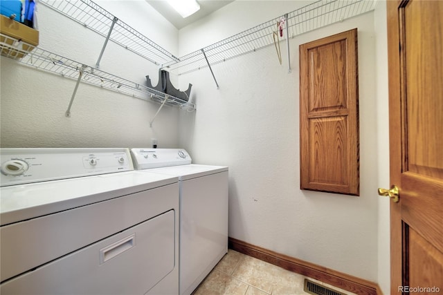 laundry area with light tile patterned flooring and washer and dryer