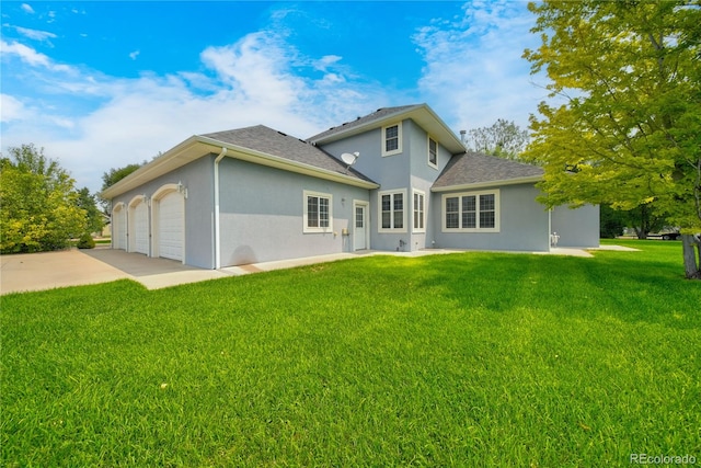 rear view of property with a yard and a garage