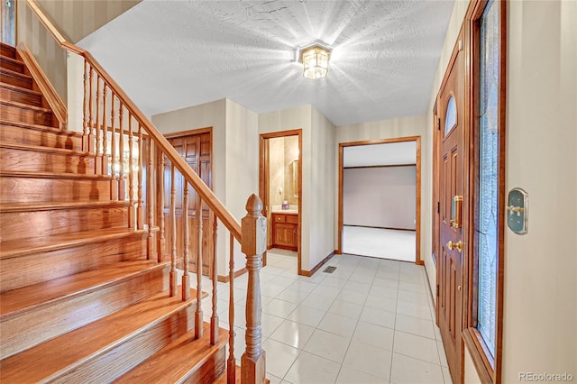 tiled foyer with a textured ceiling