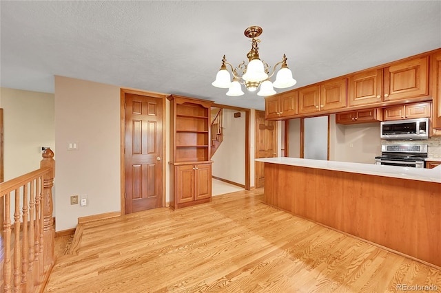 kitchen with hanging light fixtures, an inviting chandelier, light hardwood / wood-style flooring, decorative backsplash, and appliances with stainless steel finishes