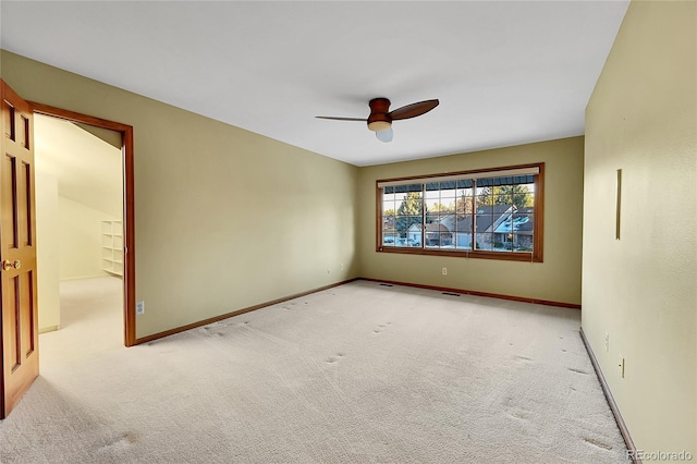 carpeted spare room featuring ceiling fan