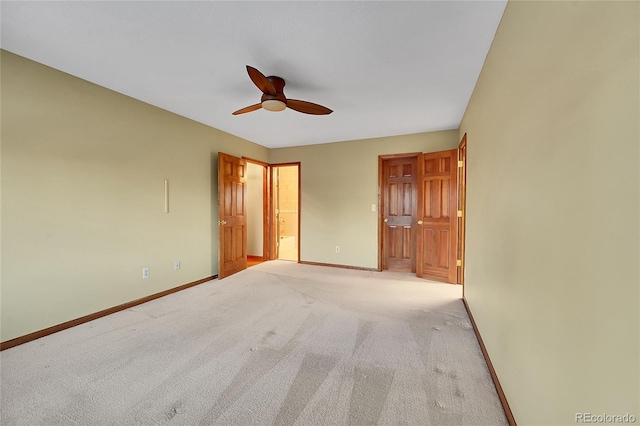 unfurnished bedroom featuring connected bathroom, light colored carpet, and ceiling fan