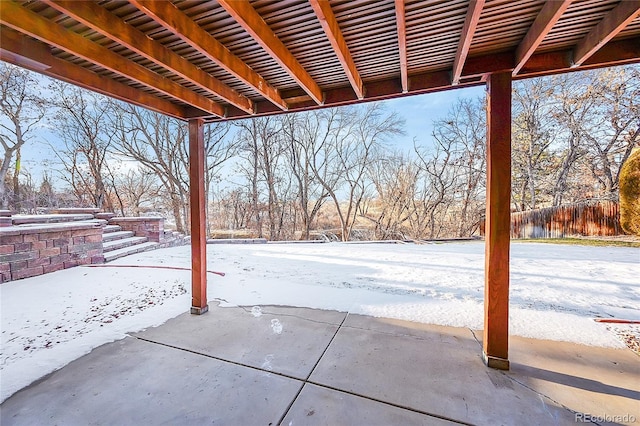 yard layered in snow featuring a patio