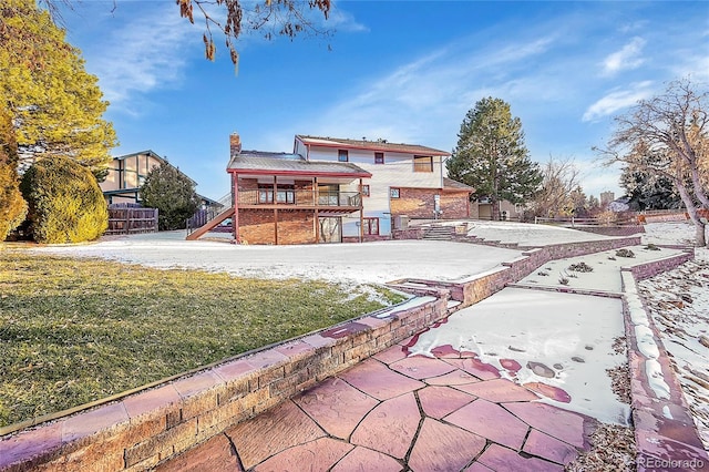 rear view of property featuring a lawn