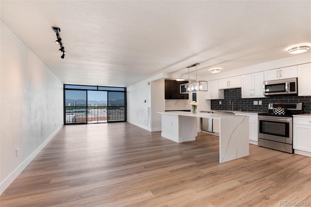 2 Adams St Unit 1504, Denver, CO 80206 - kitchen featuring stainless steel appliances, open floor plan, light countertops, a kitchen island, and tasteful backsplash