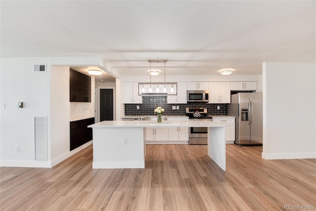 2 Adams St Unit 1504, Denver, CO 80206 - kitchen featuring appliances with stainless steel finishes, a kitchen island, light countertops, and backsplash