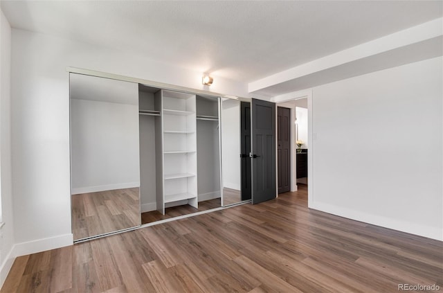 2 Adams St Unit 1504, Denver, CO 80206 - unfurnished bedroom with wood finished floors and a closet