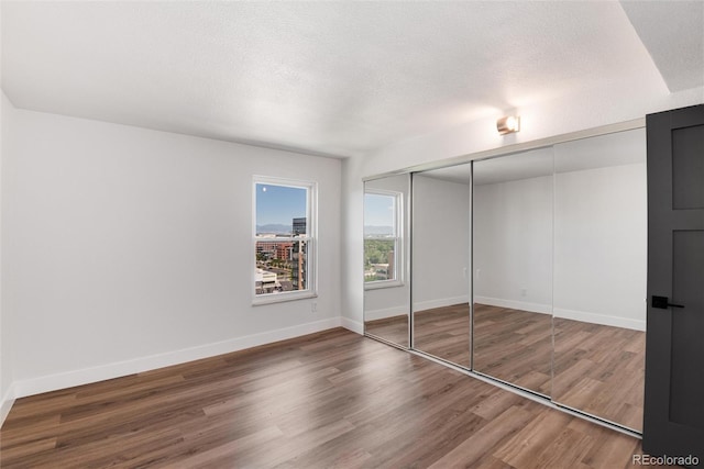 2 Adams St Unit 1504, Denver, CO 80206 - unfurnished bedroom featuring wood finished floors, a textured ceiling, and a closet