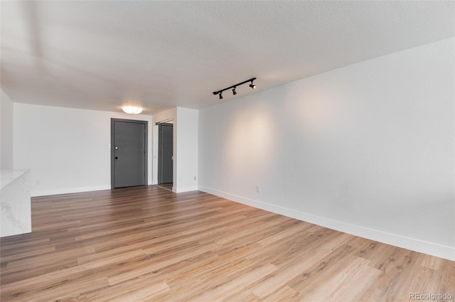 2 Adams St Unit 1504, Denver, CO 80206 - empty room with rail lighting, wood finished floors, and a textured ceiling