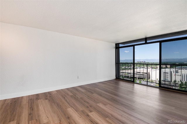 2 Adams St Unit 1504, Denver, CO 80206 - unfurnished room featuring a wall of windows and wood finished floors