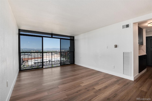 2 Adams St Unit 1504, Denver, CO 80206 - spare room featuring floor to ceiling windows and wood finished floors