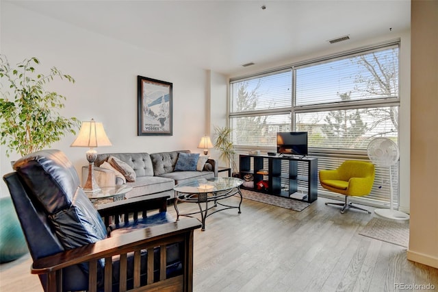 living room featuring visible vents, wood finished floors, and baseboards