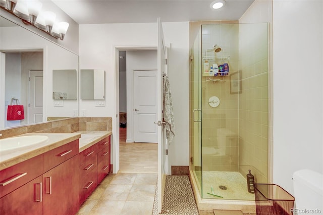 bathroom with toilet, tile patterned flooring, a shower stall, vanity, and recessed lighting
