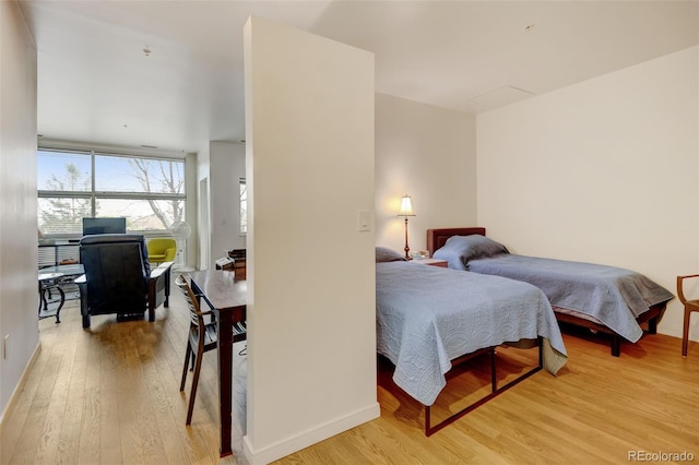 bedroom featuring baseboards and light wood finished floors