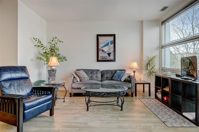 living room featuring light wood-style flooring and visible vents