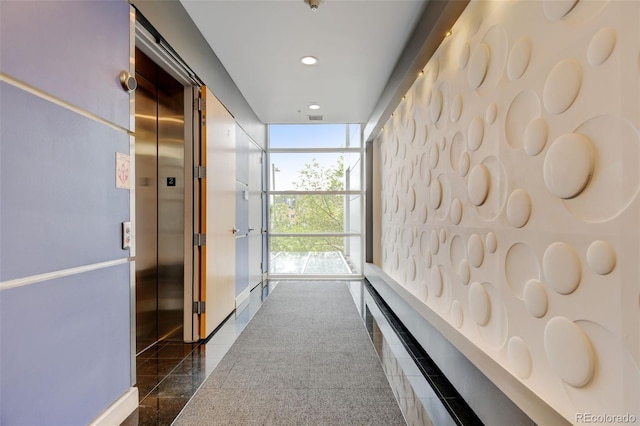 corridor featuring a wall of windows, granite finish floor, visible vents, and recessed lighting