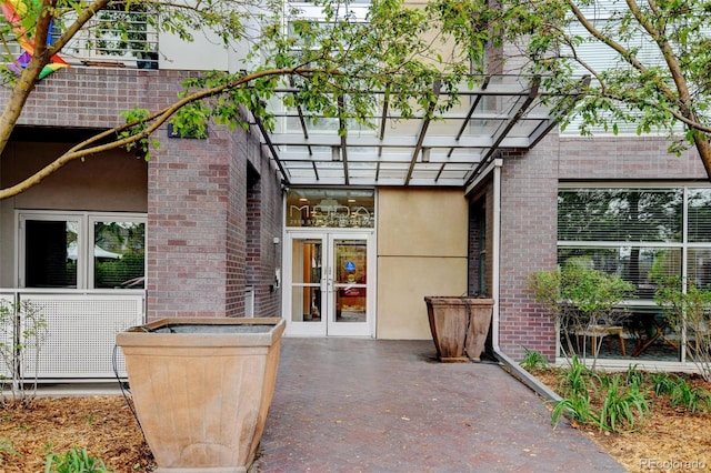 exterior space with a pergola, stucco siding, french doors, and brick siding
